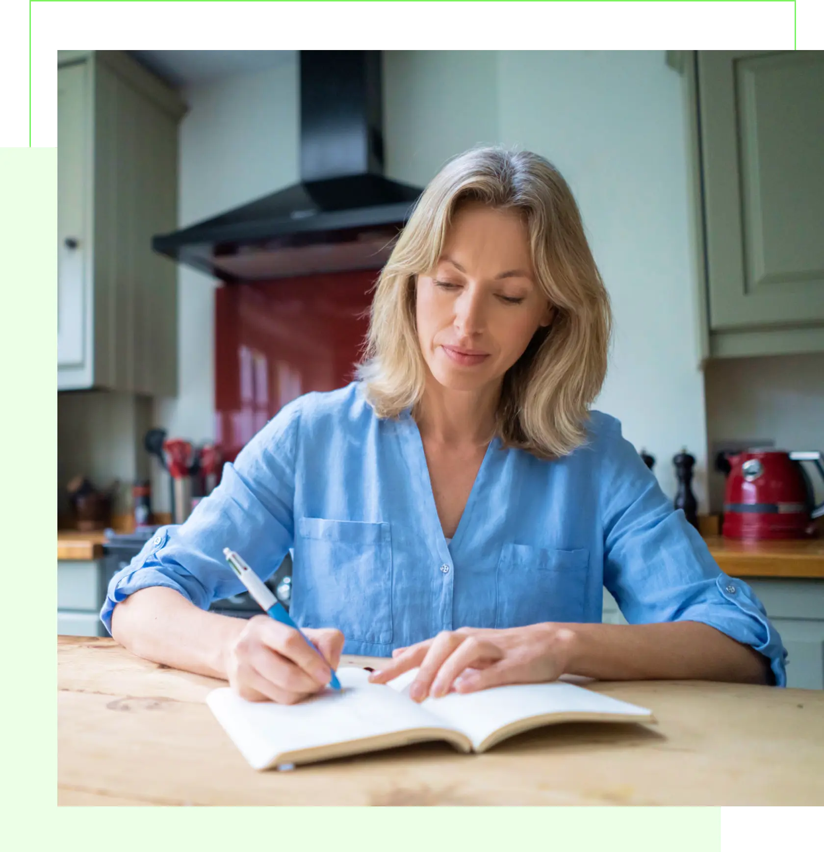 Woman writing in notebook at kitchen table.